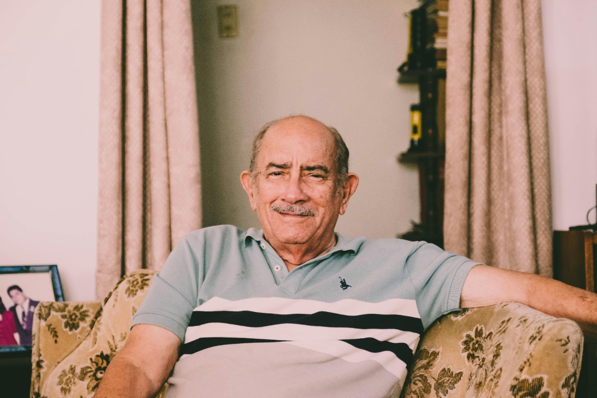 elderly man sitting on a chair, smiling