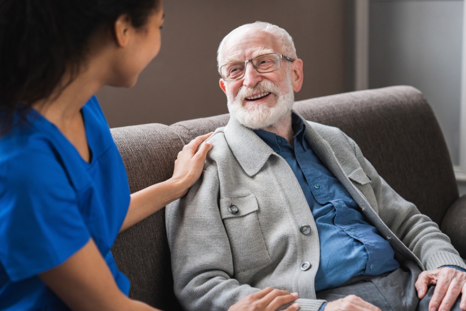 elderly man smiling with carer