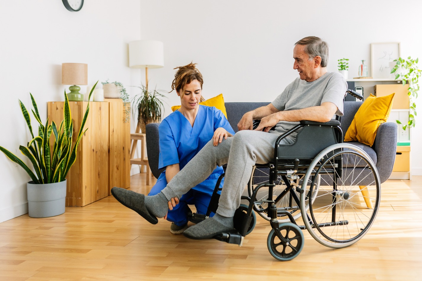 carer helping elderly person in wheelchair